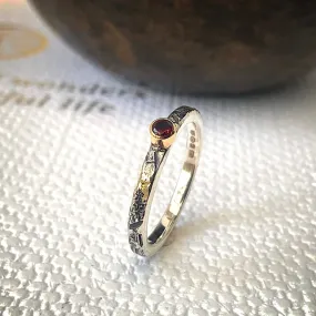 Solid sterling silver and gold ring set with a deep red garnet. Size Q1/2